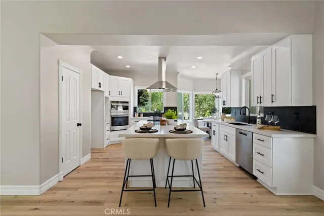 a kitchen with stainless steel appliances a stove a sink and a refrigerator