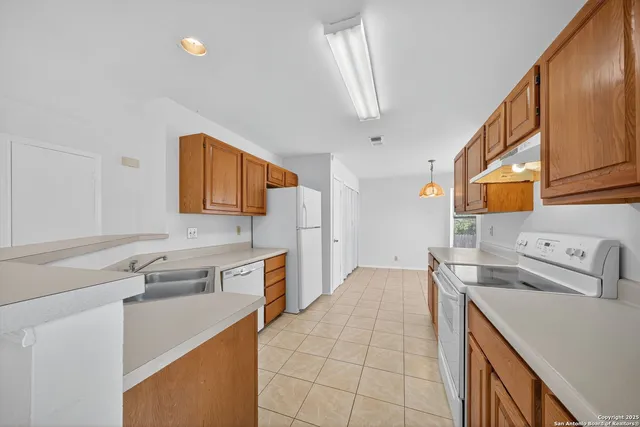 a kitchen with a sink a stove and cabinets