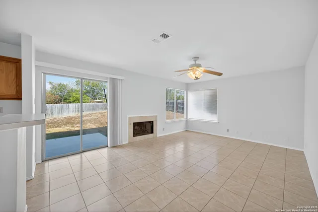 a view of empty room with cabinet and fan