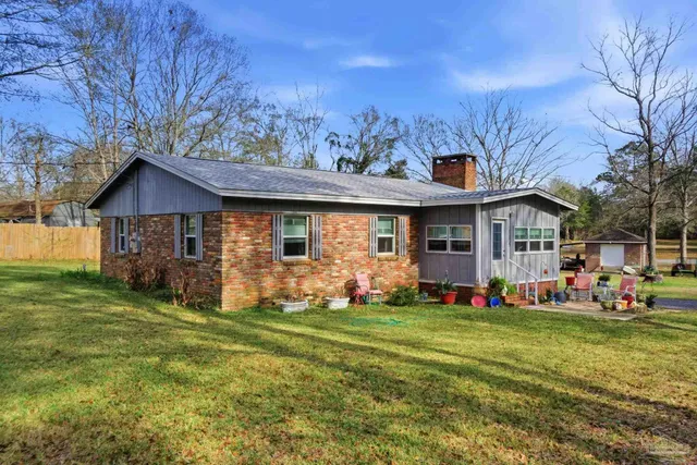 a front view of house with yard barbeque and outdoor seating