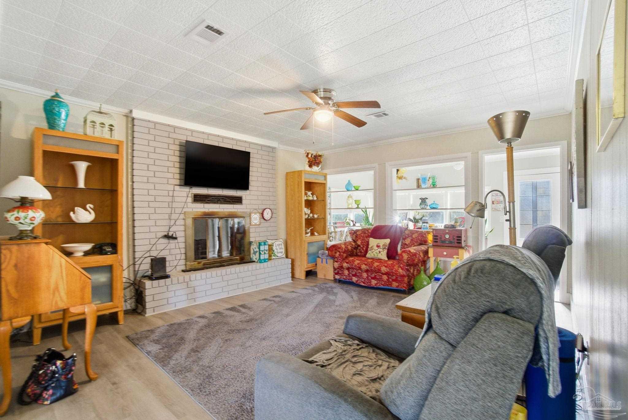 148 San Carlos Road Cantonment, FL 32533 - Photo 11 of 38 a living room with furniture a flat screen tv and a fireplace