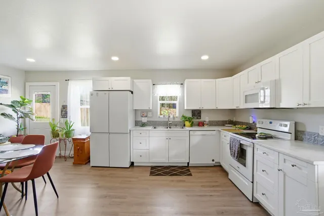 a kitchen with stainless steel appliances a refrigerator a stove a sink cabinets and a dining table