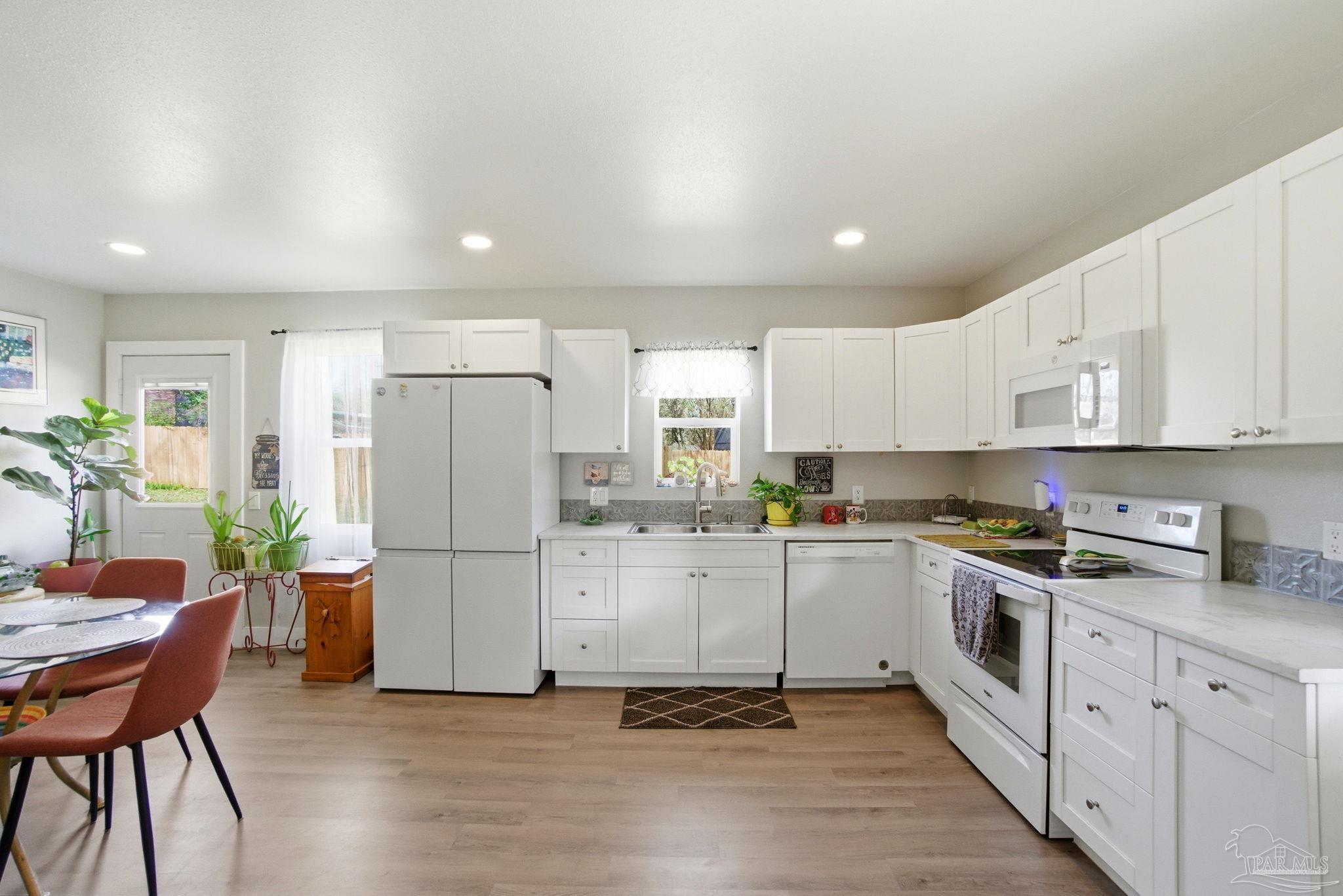 148 San Carlos Road Cantonment, FL 32533 - Photo 12 of 38 a kitchen with stainless steel appliances a refrigerator a stove a sink cabinets and a dining table