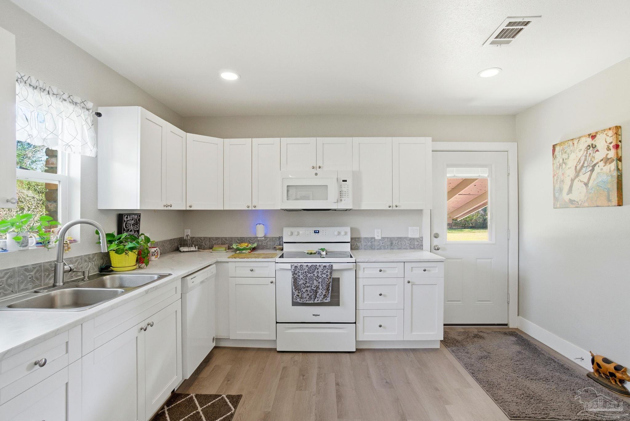 148 San Carlos Road Cantonment, FL 32533 - Photo 14 of 38 a kitchen with cabinets stainless steel appliances a sink and wooden floor