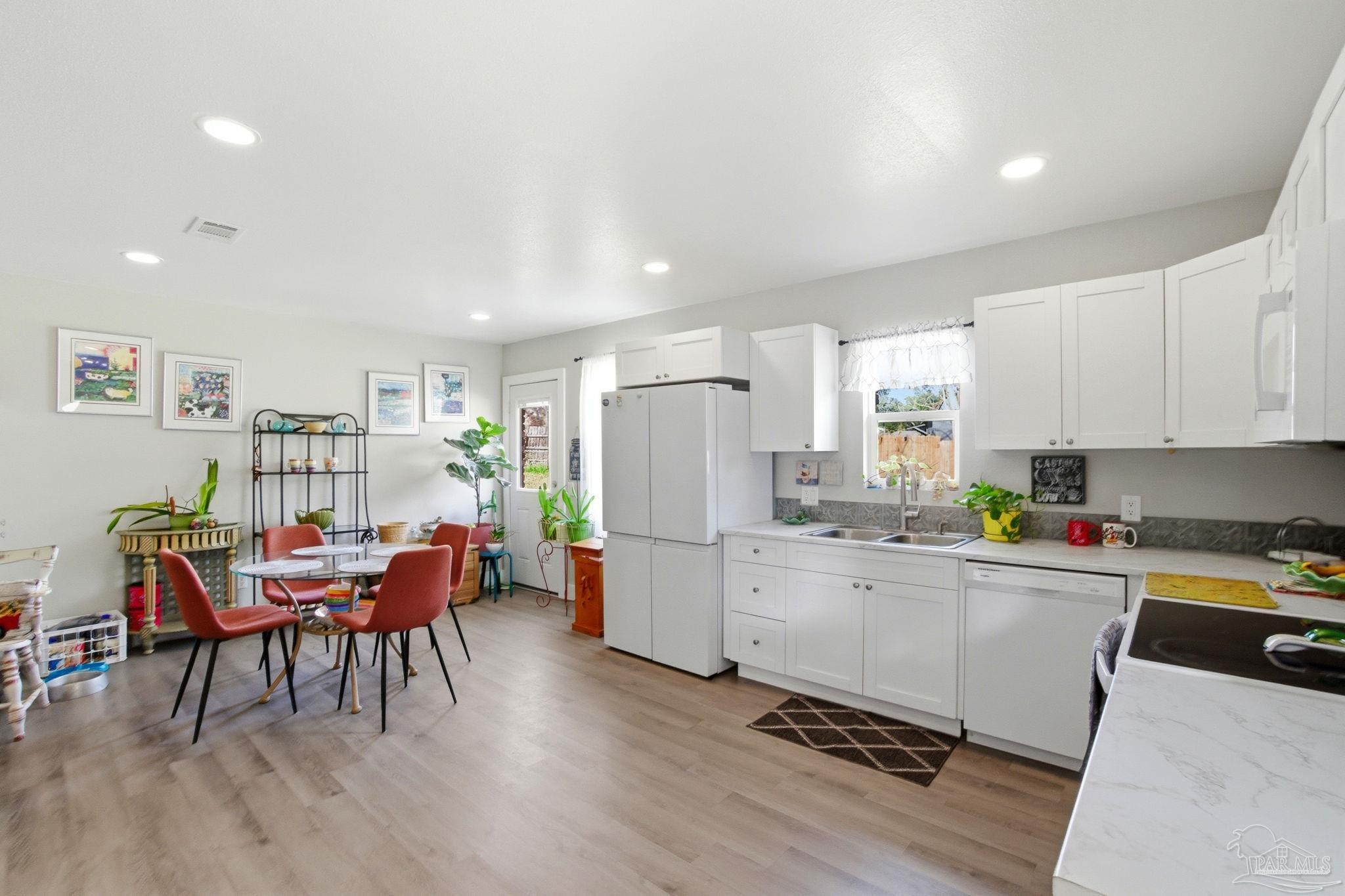 148 San Carlos Road Cantonment, FL 32533 - Photo 15 of 38 a kitchen with a dining table chairs and white appliances