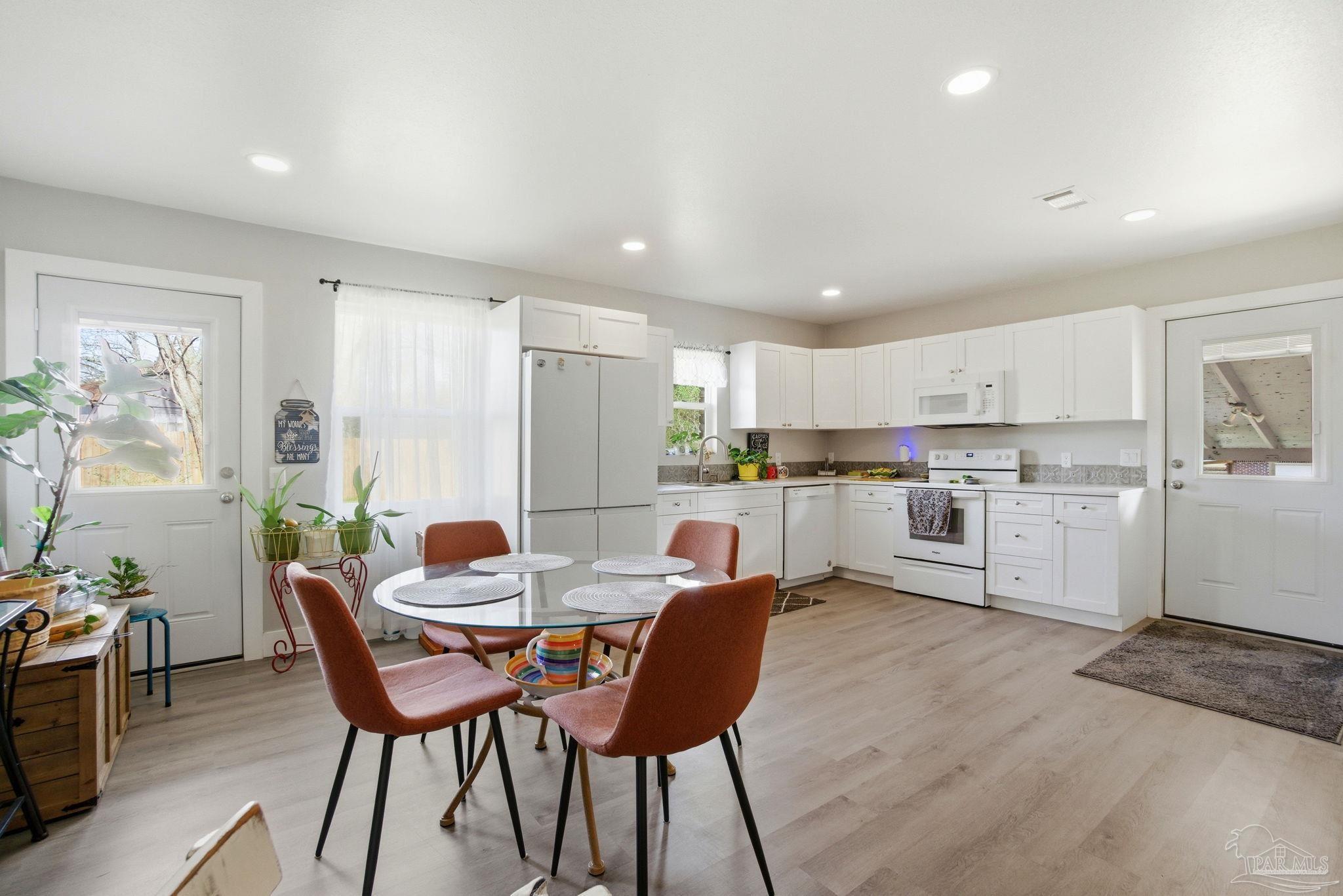 148 San Carlos Road Cantonment, FL 32533 - Photo 17 of 38 a kitchen with a dining table chairs and refrigerator