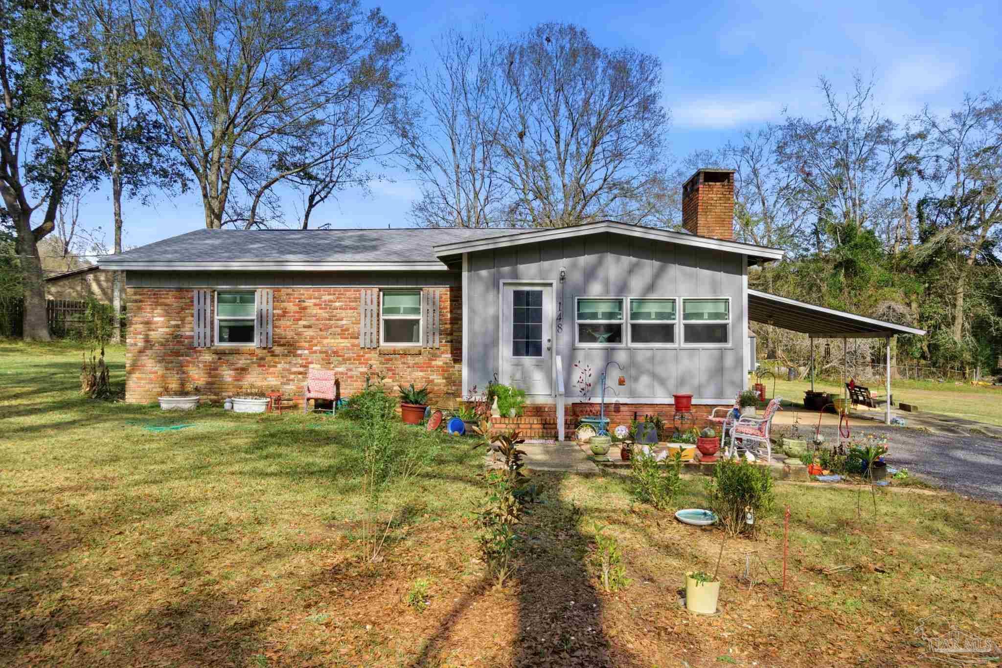 148 San Carlos Road Cantonment, FL 32533 - Photo 2 of 38 a front view of a house with garden