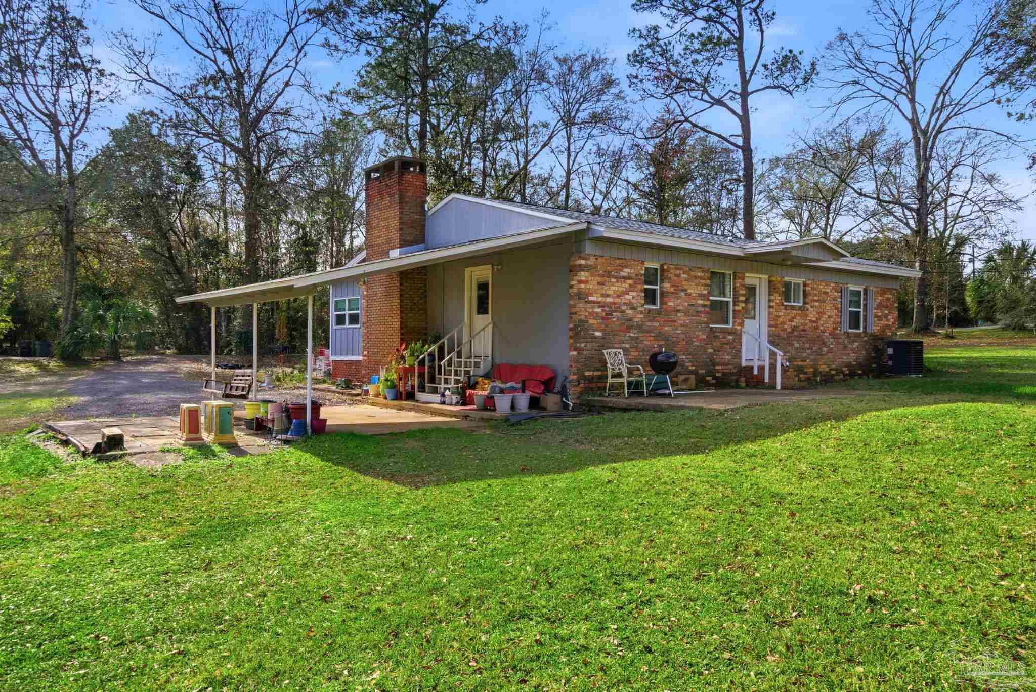 148 San Carlos Road Cantonment, FL 32533 - Photo 32 of 38 a view of a house with backyard porch and sitting area