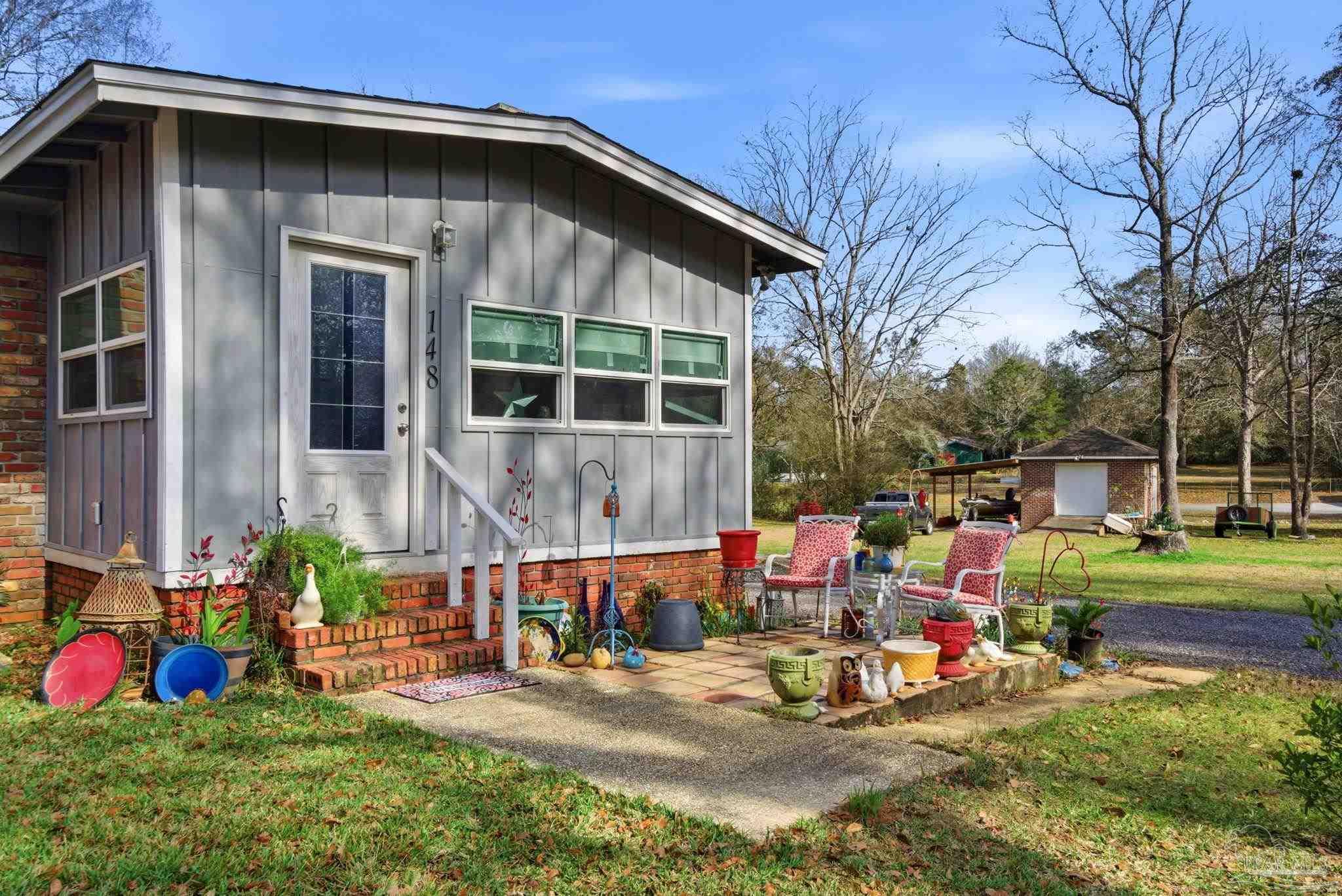 148 San Carlos Road Cantonment, FL 32533 - Photo 5 of 38 a view of backyard with outdoor seating and trees in the background