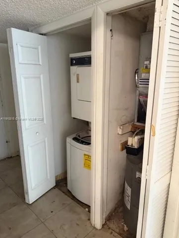 a utility room with a refrigerator and washer