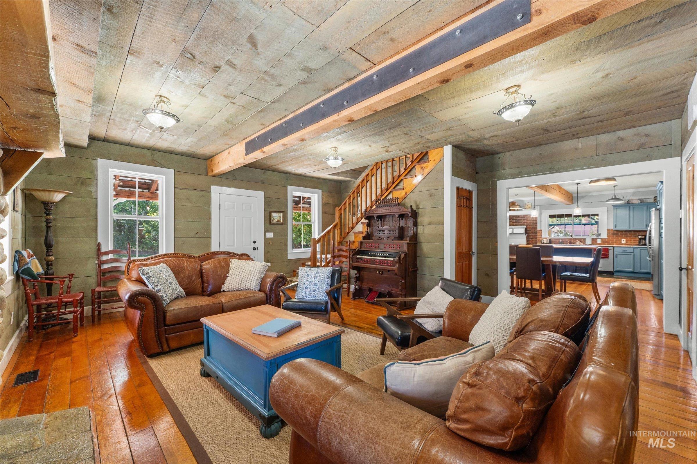 315 South Middlefork Road Garden Valley, ID 83622 - Photo 5 of 49 Living room featuring light wood-type flooring, wooden walls, stairs, and a wooden ceiling with exposed beams
