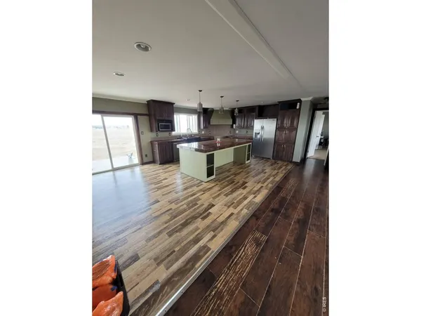 a kitchen with kitchen island a counter top space a sink stainless steel appliances and cabinets