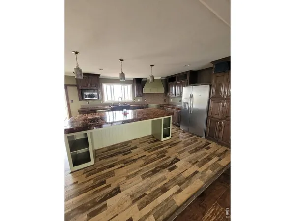 a kitchen with stainless steel appliances granite countertop a kitchen island a stove and a sink