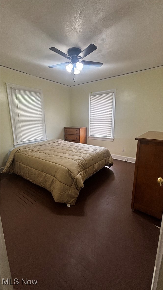 15710 Hazel Road Cleveland, OH 44112 - Photo 20 of 44 Bedroom with baseboards, a ceiling fan, dark carpet, and a textured ceiling
