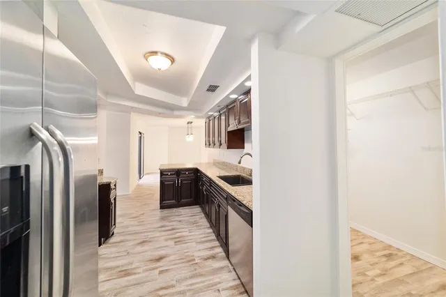 a kitchen with stainless steel appliances granite countertop a refrigerator and a stove