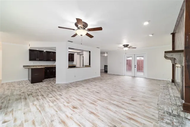 a view of a livingroom with a flat screen tv kitchen view and a fireplace