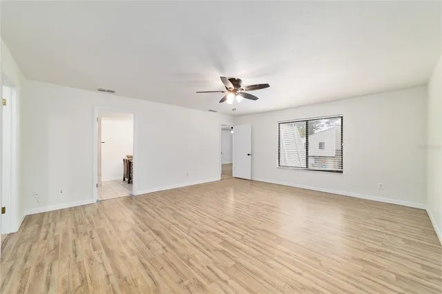 a view of an empty room with wooden floor