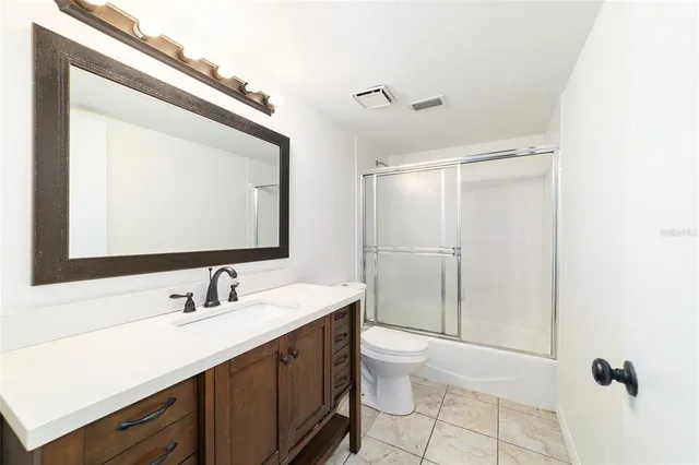 a bathroom with a double vanity sink toilet mirror and shower