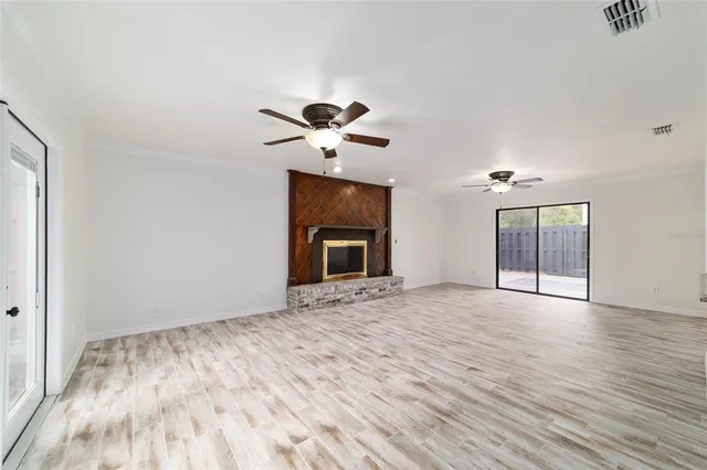 a view of an empty room with a fireplace and a window