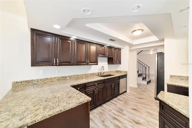 a large kitchen with granite countertop a sink and cabinets
