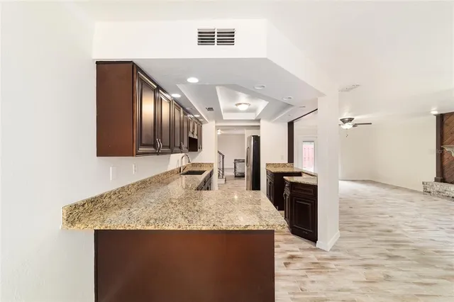 a view of a kitchen with granite countertop a sink dishwasher stove and oven