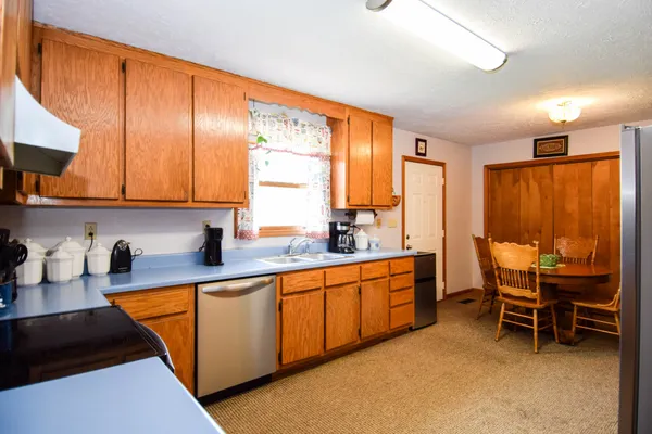 a kitchen with stainless steel appliances granite countertop sink table and chairs