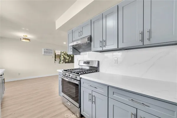a kitchen with granite countertop cabinets stainless steel appliances and a wooden floor
