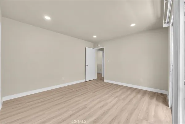 a view of an empty room with wooden floor