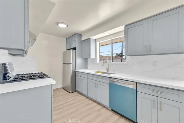 a kitchen with stainless steel appliances a sink stove and refrigerator
