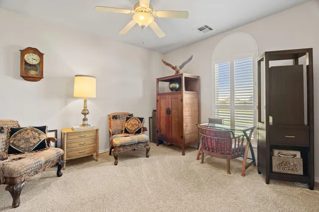 a view of a workspace with furniture and a window