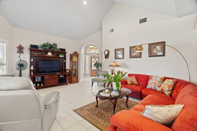 a living room with furniture a flat screen tv and a window