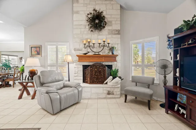 a living room with furniture a fireplace and a flat screen tv