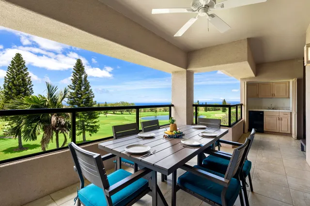 a view of a dining table and chairs with the ocean view