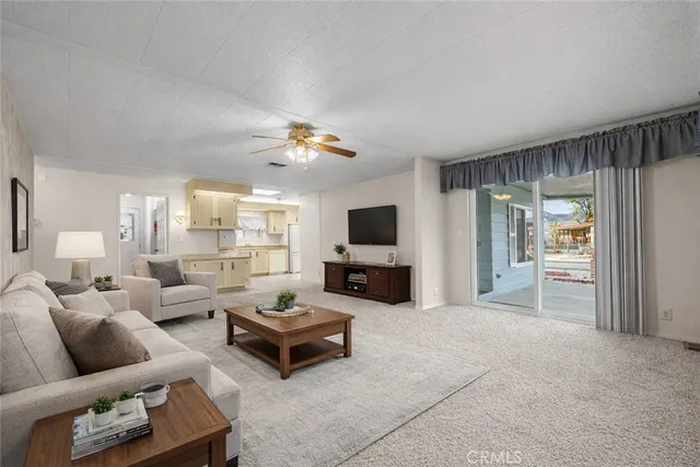 an empty room with chandelier fan and windows