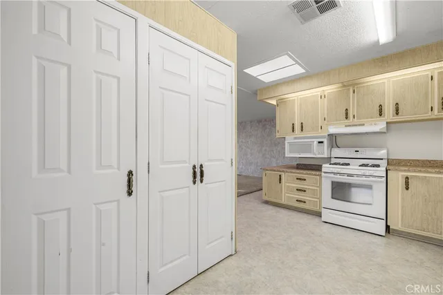 a kitchen with granite countertop white cabinets and white appliances