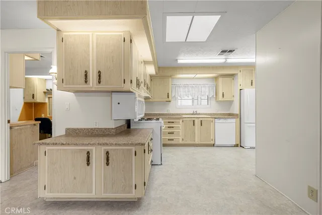 a kitchen with white cabinets and white appliances