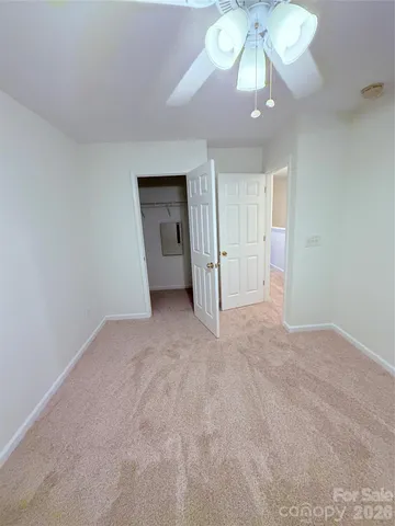 a view of an empty room with a chandelier fan