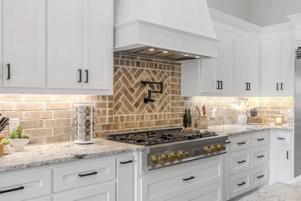 a kitchen with granite countertop white cabinets and appliances