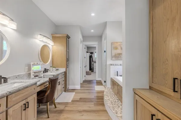 a spacious bathroom with a double vanity sink a mirror and a shower