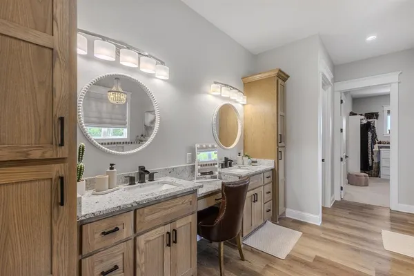 a en suite bathroom with a granite countertop double vanity sink and a mirror