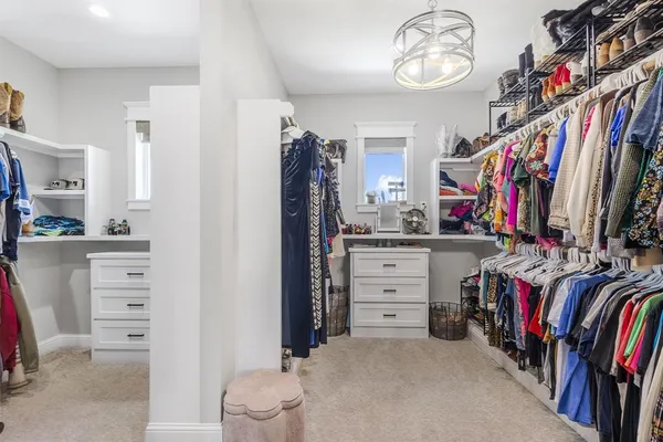 a view of walk in closet with clothes and shoes