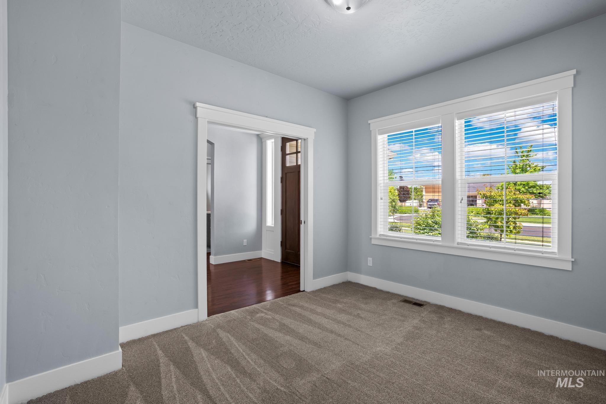 2681 East Rhyolite Court Nampa, ID 83686 - Photo 7 of 48 Interior space featuring light gray wall paint, white trim, and textured gray carpeting