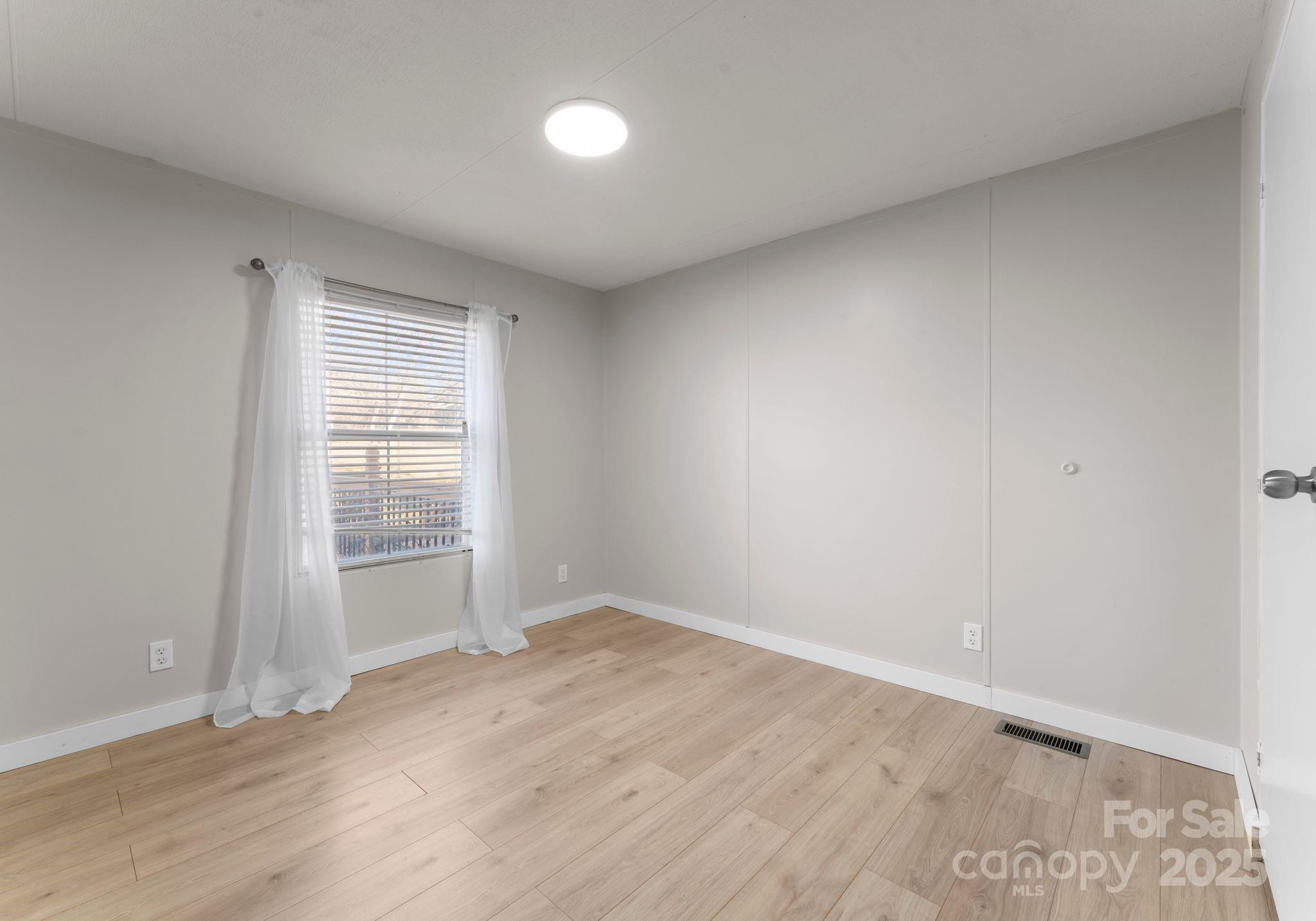 1812 Shearers Road Davidson, NC 28036 - Photo 24 of 40 an empty room with wooden floor and windows