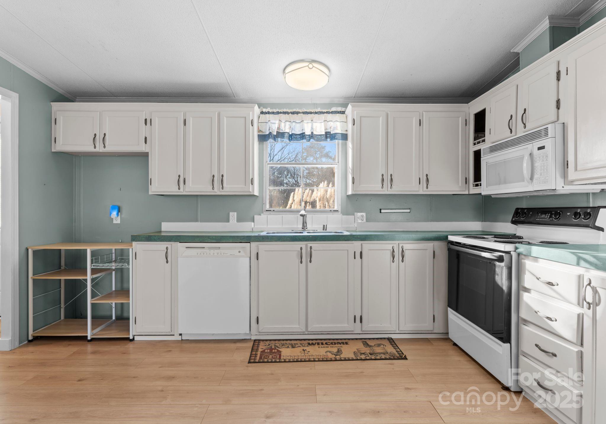 1812 Shearers Road Davidson, NC 28036 - Photo 8 of 40 a kitchen with granite countertop a stove a sink and a white cabinets