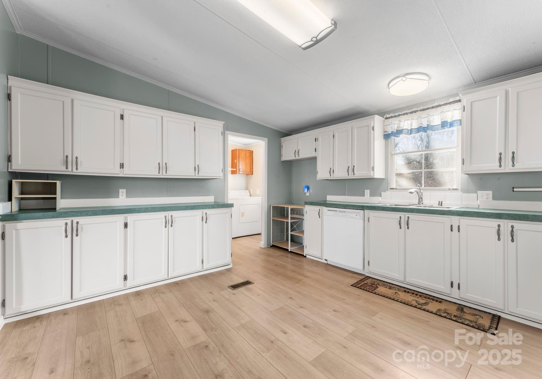 1812 Shearers Road Davidson, NC 28036 - Photo 9 of 40 a kitchen with granite countertop white cabinets white stainless steel appliances and sink