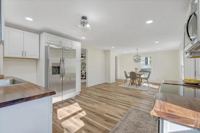 a kitchen with stainless steel appliances kitchen island granite countertop a refrigerator and a sink