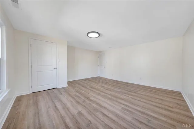 a view of a room with wooden floor and white walls