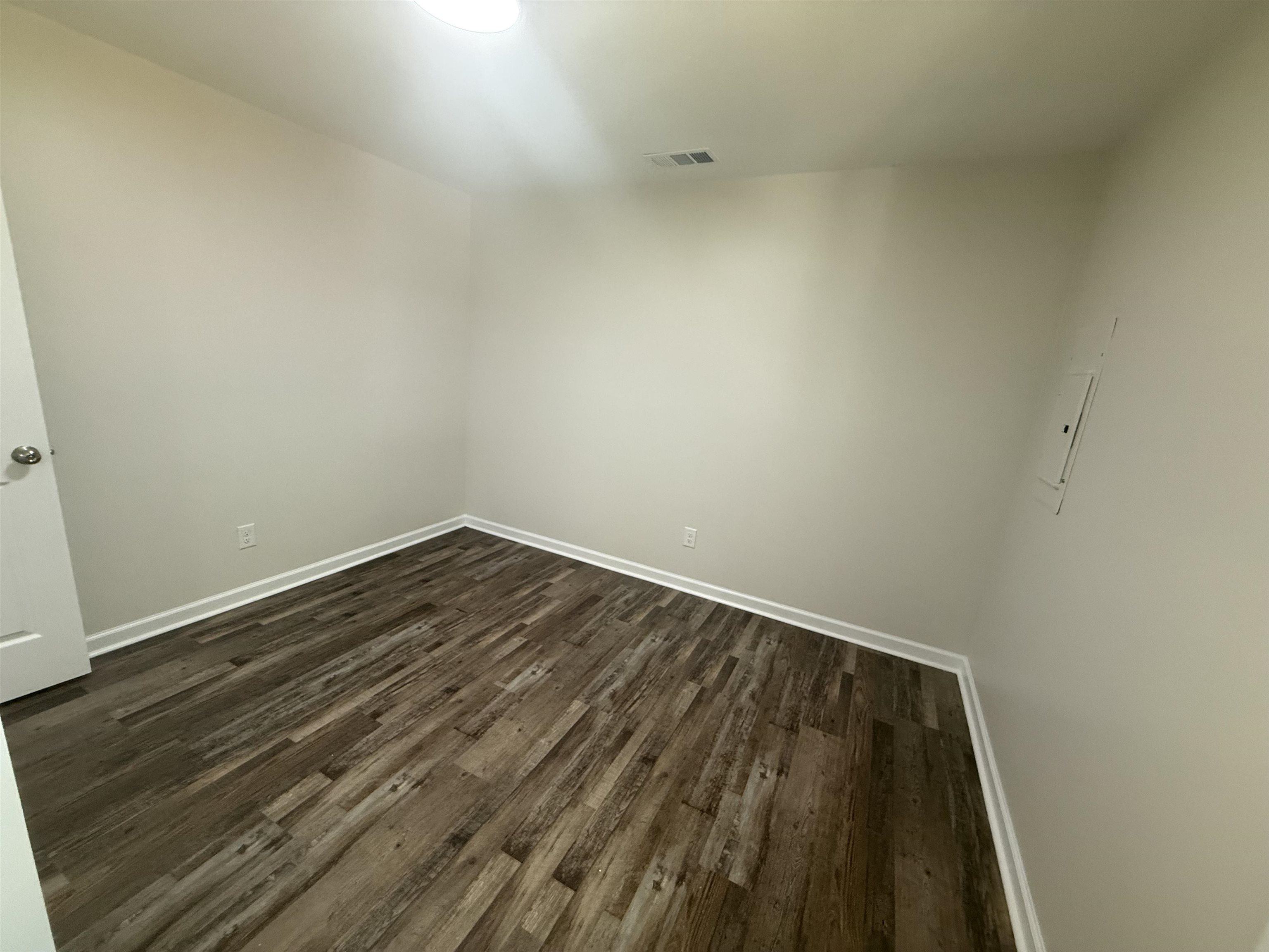 195 Poole Road Moscow, TN 38057 - Photo 13 of 21 Neutral tone walls with white trim, wood-finish flooring, and a flush-mount ceiling light fixture