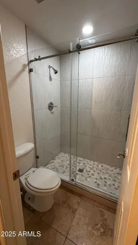 a bathroom with a toilet and a shower