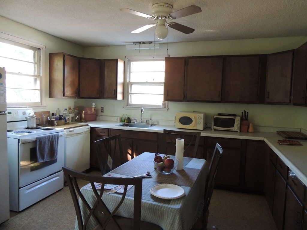 248 Fiberloid Street Springfield, MA 01151 - Photo 13 of 23 a kitchen with a stove a sink a dining table and chairs